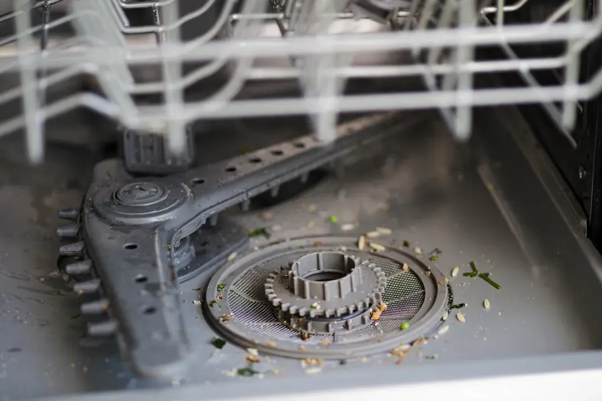 Dishwasher tub with the lower spray arm and round filter cap visible
