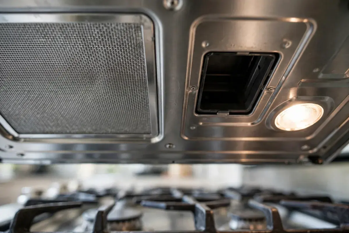 Underside of an over the range microwave showing the grease filter and lamp